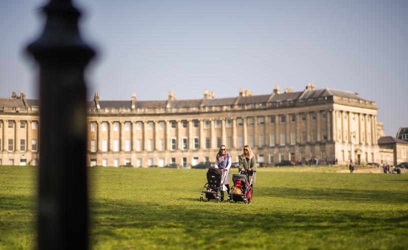 People pushing prams across the Royal Crescent lawn